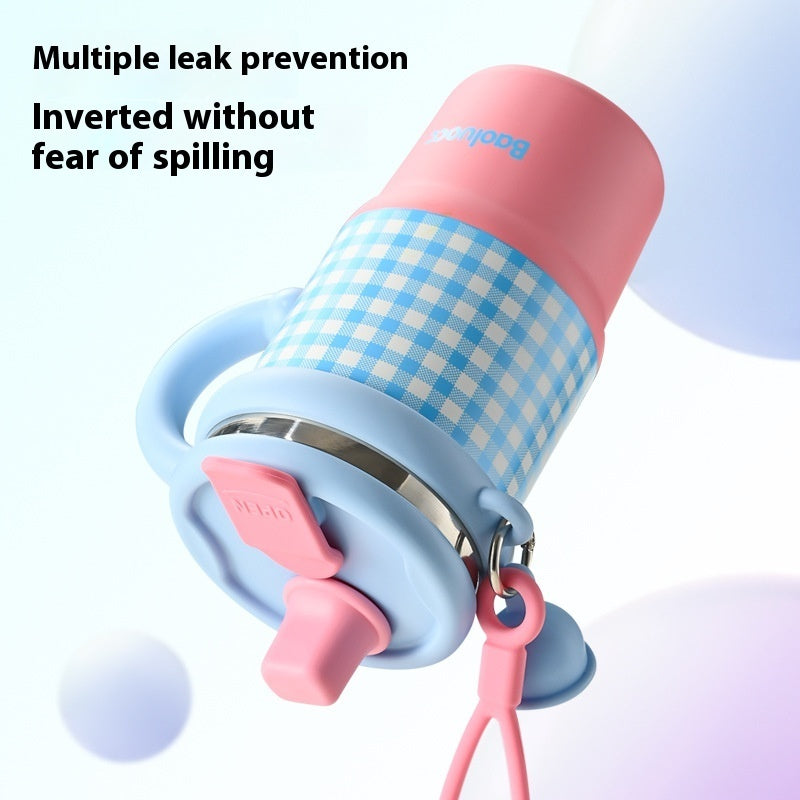 Pink and blue checkered cup with multiple leak prevention features on a light purple background