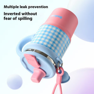 Pink and blue checkered cup with multiple leak prevention features on a light purple background